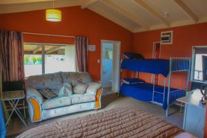 - un salon avec un canapé et des lits superposés dans l'établissement Central City Camping Park, à Invercargill