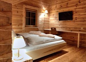 a bedroom with a bed in a wooden wall at Chalet4You in Haus im Ennstal