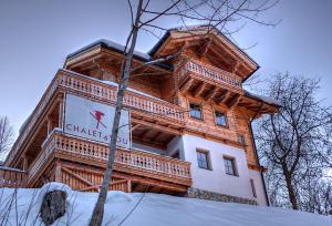 a large wooden building with a sign on it at Chalet4You in Haus im Ennstal