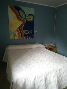 Al lado في قرطبة: سرير في غرفة نوم مع لوحة على الحائط +12 صورة