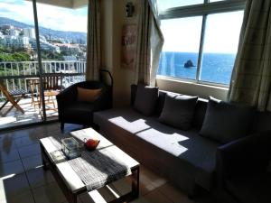 - un salon avec un canapé et une grande fenêtre dans l'établissement Apartamentos do mar 303, à Funchal