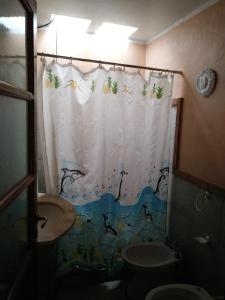 y baño con aseo y cortina de ducha. en Al lado en Córdoba