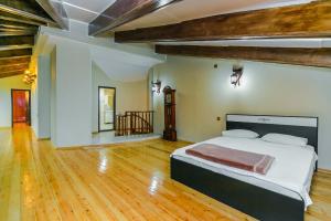 ein Schlafzimmer mit einem großen Bett in einem Zimmer mit Holzböden in der Unterkunft 4 Bedrooms Beautiful City Center in Baku