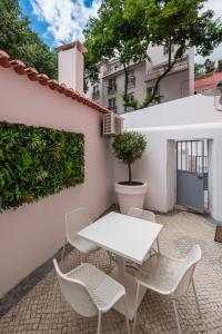 a patio with a white table and chairs at Santo António House - Exclusive Apartment in Lisbon