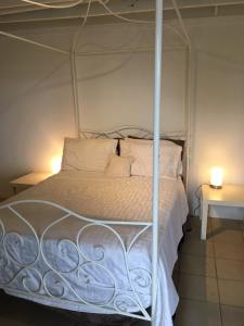 a bedroom with a white bed with a metal canopy at Parkview Brisbane in Brisbane