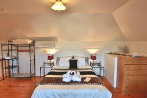 two stuffed animals sitting on a bed in a bedroom at Stamps of Stanley in Stanley