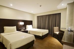 Postel nebo postele na pokoji v ubytování Pearl Garden Hotel