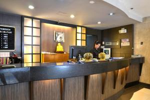 a woman standing at a counter in a restaurant at Pearl Garden Hotel in Manila