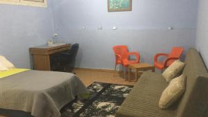 - une chambre avec un lit, un bureau et des chaises dans l'établissement A studio / private room in New Cairo, au Caire