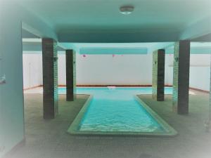 a swimming pool in a building with pillars in it at A studio / private room in New Cairo in Cairo