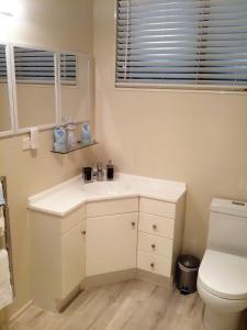 a bathroom with a white sink and a toilet at Paradise Views Luxury 2BR Apartment in Paihia