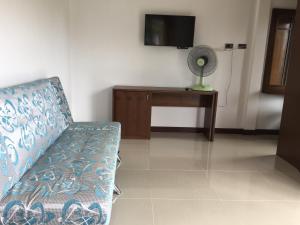 Una sala de estar con un sofá y un televisor. en Tara House, en Ko Lanta