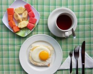 a plate of food with an egg and a cup of coffee at Shiva House in Ubud