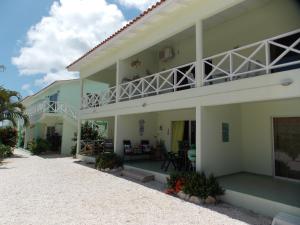 a large white building with a balcony and a patio at Bon Bini Lagun Curacao in Lagun