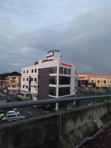 a hotel building with a parking lot in front of it at Sp Central Hotel in Sungai Petani
