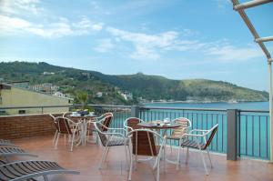 balcone con tavoli, sedie e vista sull'acqua di B&B Residence Eco Del Mare a Palinuro