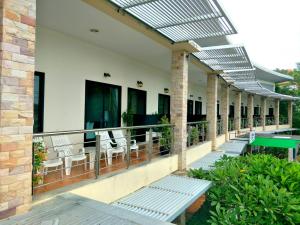 a balcony of a house with chairs and a table at Green Residence Hotel in Bang Rak Beach