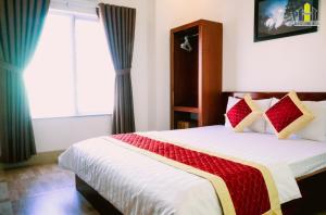 1 dormitorio con 1 cama con manta roja y blanca en Hoàng Hưng Hotel en Quy Nhon