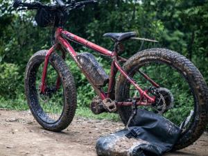 una bici parcheggiata su una strada sterrata con una borsa di Chateau Orientale Resort a Luang Prabang