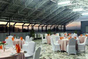 a banquet hall with white tables and white chairs at Grand Hatika Hotel in Tanjungpandan