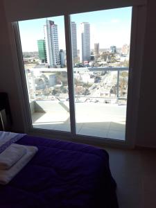 1 dormitorio con vistas a la ciudad desde una ventana en APART MAIPU 190 en Río Cuarto