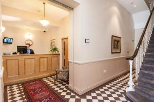 a man standing at the reception desk of a house at The Coronation Hotel in London