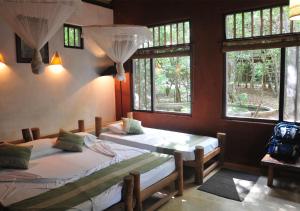 a bedroom with two beds and a window at Back of Beyond - Pidurangala in Sigiriya
