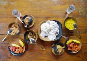 a wooden table topped with bowls of food at Back of Beyond - Pidurangala in Sigiriya