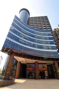 un edificio alto con una torre encima en Monarch Skyline Hotel, en Luzhu