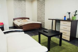 Schlafzimmer mit einem Bett, einem Schreibtisch und einem Tisch in der Unterkunft Apart Inn in Nowokusnezk