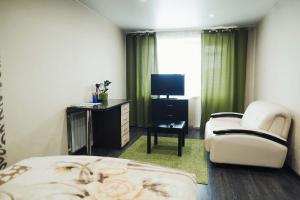 ein Hotelzimmer mit einem Bett, einem Stuhl und einem TV in der Unterkunft Apart Inn in Nowokusnezk