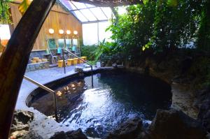 una piscina d'acqua in un cortile con un edificio di Ryoufuso a Tsu