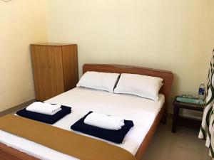 a bedroom with a bed with two towels on it at Palm Grove Service Villa in Cochin