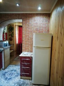 ヘルソンにある2-х комнатная квартираのレンガの壁、キッチン(冷蔵庫付)