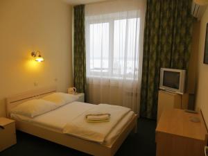 una camera d'albergo con letto e finestra di Korona Hotel a Samara