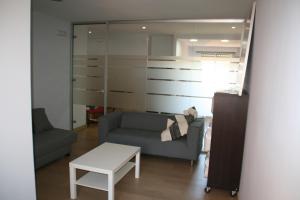 uma sala de estar com um sofá e uma mesa em Apartamento Alberche em Sevilha