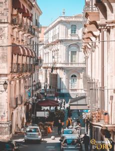 eine belebte Stadtstraße mit Autos und Gebäuden in der Unterkunft Al Quadrato D'Oro rooms in Catania