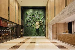 a lobby with a green wall with a chandelier at MaxOne Platinum Hayam Wuruk in Jakarta