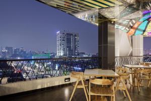 a restaurant with tables and a view of a city at MaxOne Platinum Hayam Wuruk in Jakarta