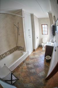 a bathroom with a tub and a toilet and a sink at The Sweetest Spot in St Lucia