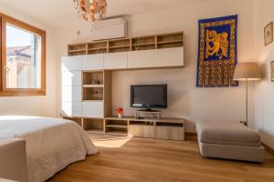 een slaapkamer met een bed en een tv aan de muur bij SUNNY NEST CANAL VIEW IN VENICE CHIC MOVIDA in Venetië