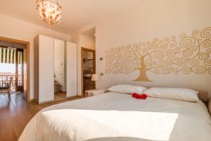 1 dormitorio con 1 cama blanca y un mural en la pared en SUNNY NEST CANAL VIEW IN VENICE CHIC MOVIDA, en Venecia