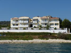 een rij huizen op het strand naast het water bij Ostria Seaside Studios and Apartments in Katarráktis