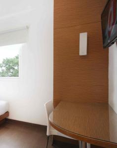 ein kleines Esszimmer mit einem Tisch und einem TV in der Unterkunft Amaris Hotel Pratama Nusa Dua in Nusa Dua