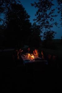 a group of people sitting around a table at night at Château d’Orion in Orion