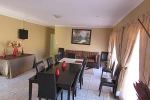 a living room with a table and chairs and a couch at Oasis Of Life Guest House in eMalahleni