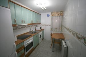 a kitchen with green cabinets and a table in it at ApartamentosAlquilerZaragoza in Zaragoza