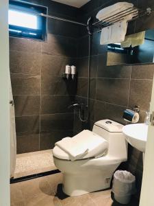 uma casa de banho com um WC e um lavatório em San Yuan Guest House em Jinning