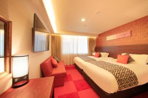 奈良市にあるセンチュリオンホテルクラシック奈良のベッド2台と赤い椅子が備わるホテルルームです。
