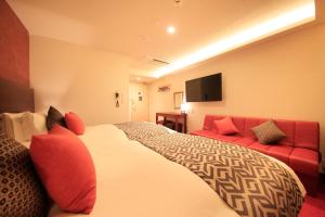 a hotel room with a bed and a red couch at Centurion Hotel Classic Nara Station in Nara